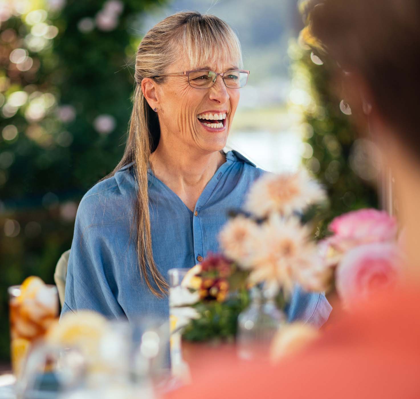 woman sitting at a table laughing